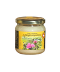 ein helles gefülltes Alpenrosenhonig Glas mit einer ansprechenden gelb grünen Etikette auf der eine pinke Alpenrose abgebildet ist. Hochwertiger Gebirgshonig mit feinem 100% Swiss Mountain Honey