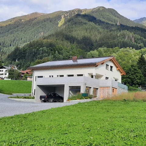 Fertiggestelltes Ökonomiegebäude der Imkerei SIMI-S-IMI in Klosters mit Solaranlage auf dem Dach, moderner, nachhaltiger Betriebsbau in alpiner Umgebung.