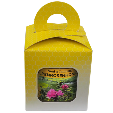 eine gelb-weiße Geschenkbox  mit Sichtfenster und  einem Alpenhonig 500g, mit Tragegriff. Rosafarbene Alpenrose Simi-s-Imihung