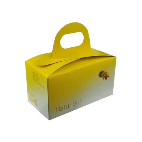 Gelbe Geschenkbox für Honig aus den Bergen mit Tragegriff und Aufdruck Natur pur in Seitenansicht