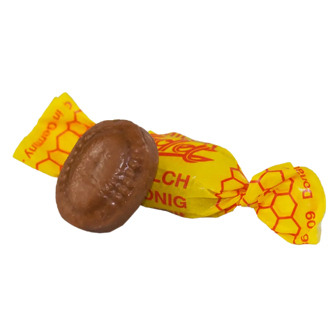eine in gelbes Papier gewickeltes Honigbonbon Milch-Honig Bonbon einzeln verpackt, freigestellt dargestellt