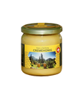 Ein Honigglas mit Cremehonig und goldenem Deckel. Das Etikett zeigt eine Landschaft mit Bienenstöcken, Bergen, Bäumen, Wabenmustern und einer Schweizer Flagge, die auf die Schweizer Herkunft hinweist. Schweizer Cremehonig im Glas, Frontansicht, fein gerührter Honig vom Imker aus Bergregionen, 100 % naturbelassen, cremige Konsistenz, hochwertige Imkerei-Qualität